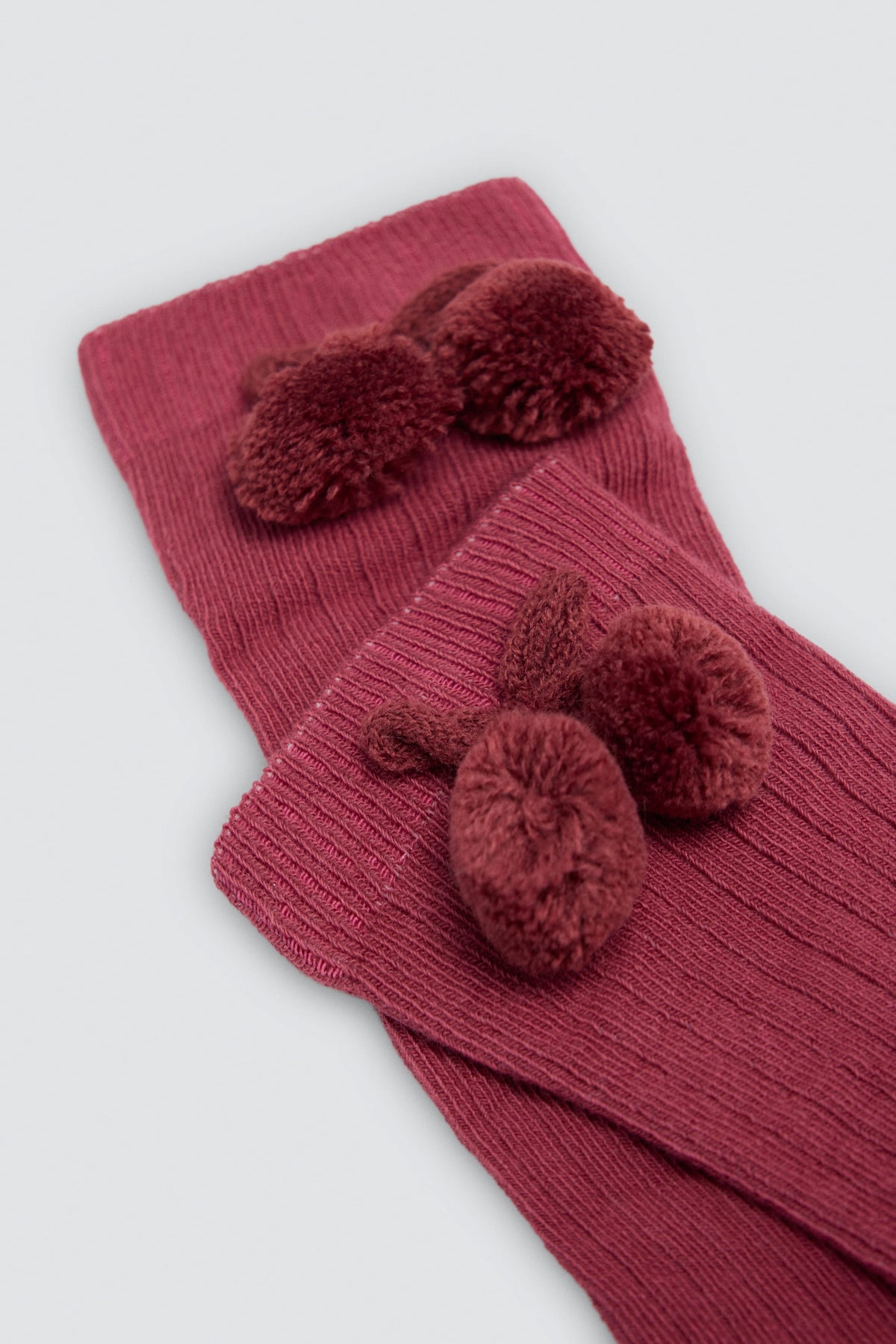 Children's long pink socks with pompom details