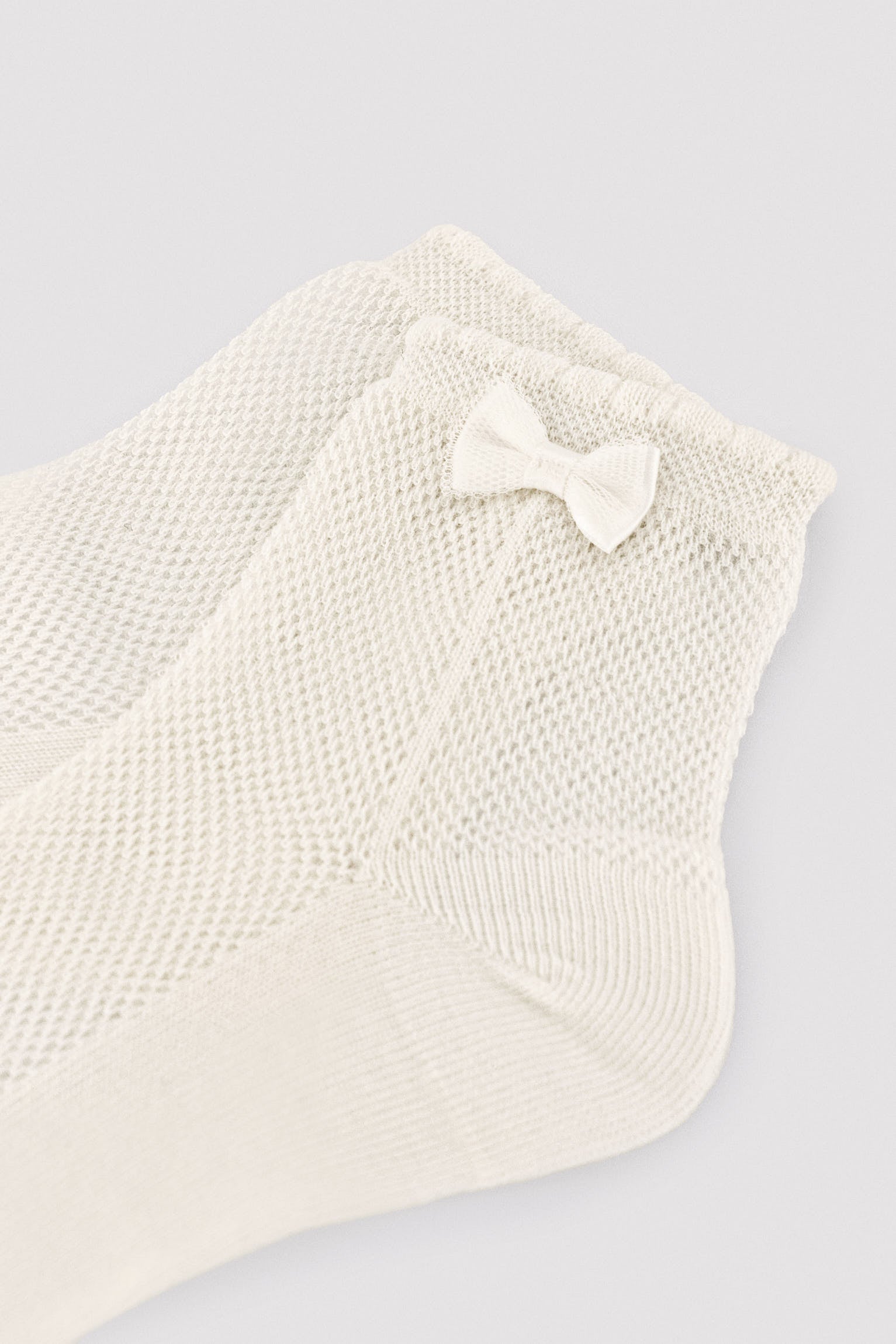 Children's openwork socks with ivory bow detail