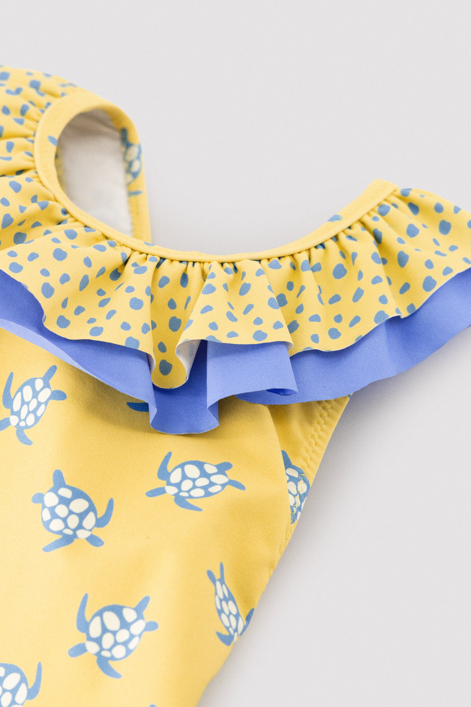 Girls' swimsuit with ruffle details and bows, turtle print