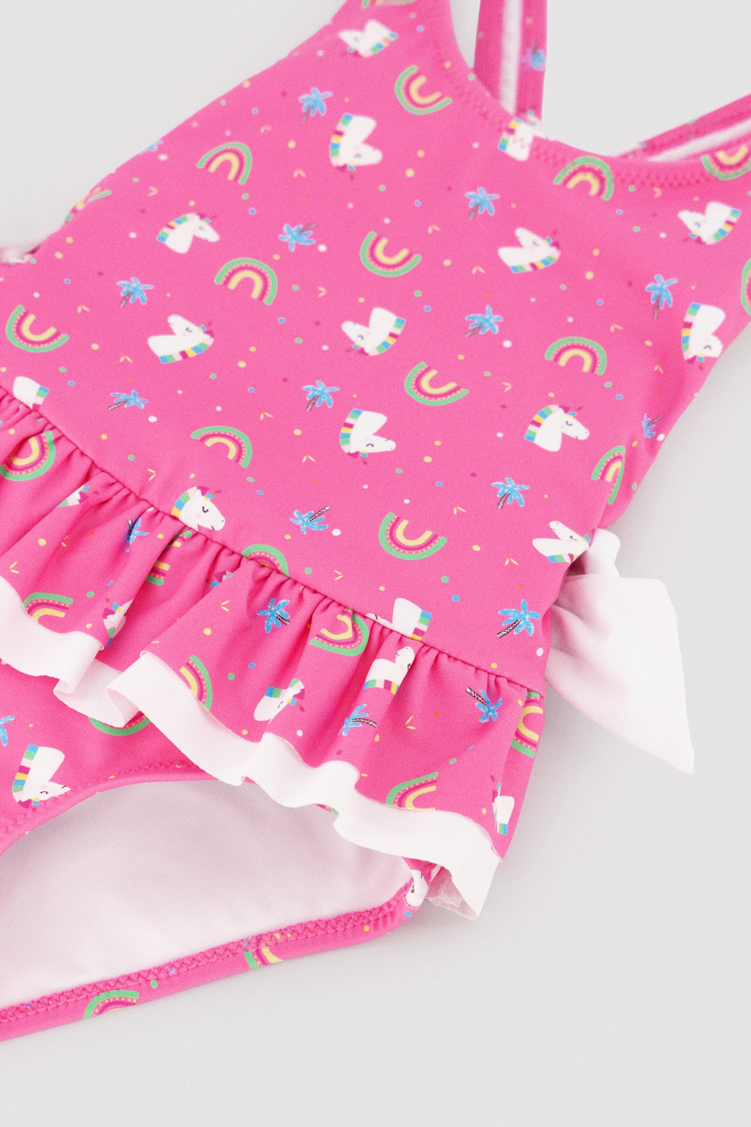 Girls' swimsuit with ruffle details and bows, unicorn print