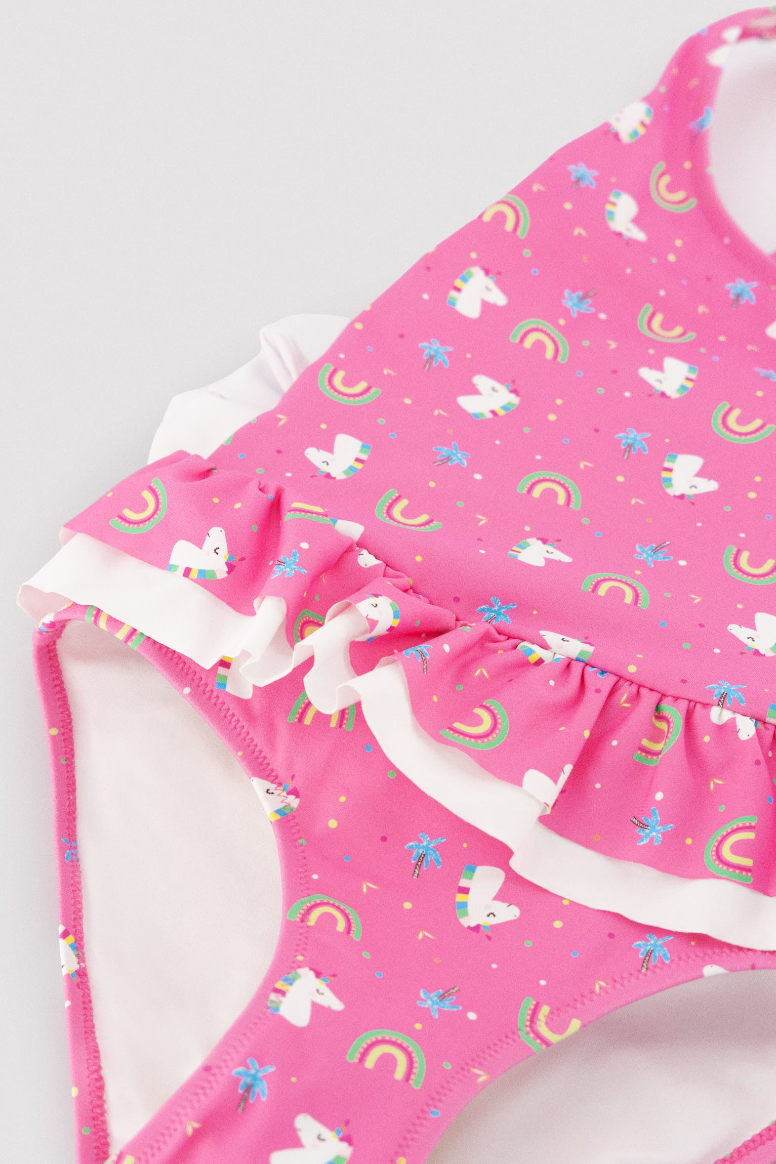 Girls' swimsuit with ruffle details and bows, unicorn print