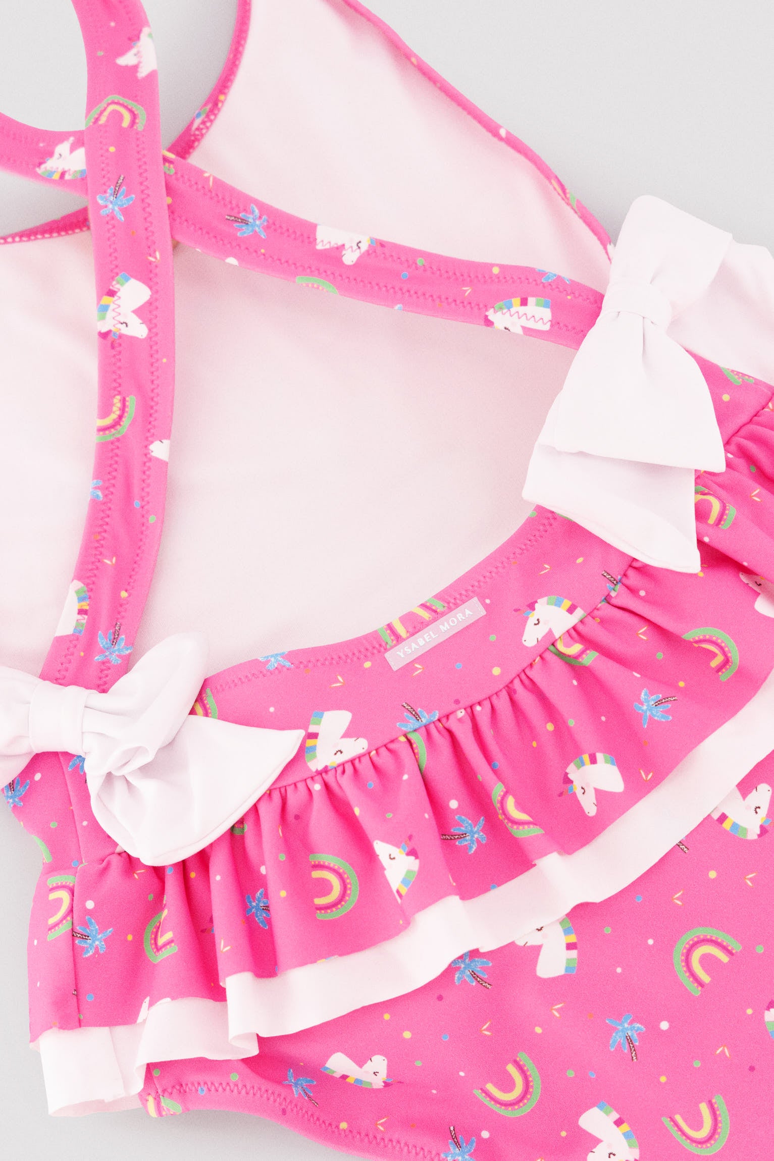 Girls' swimsuit with ruffle details and bows, unicorn print