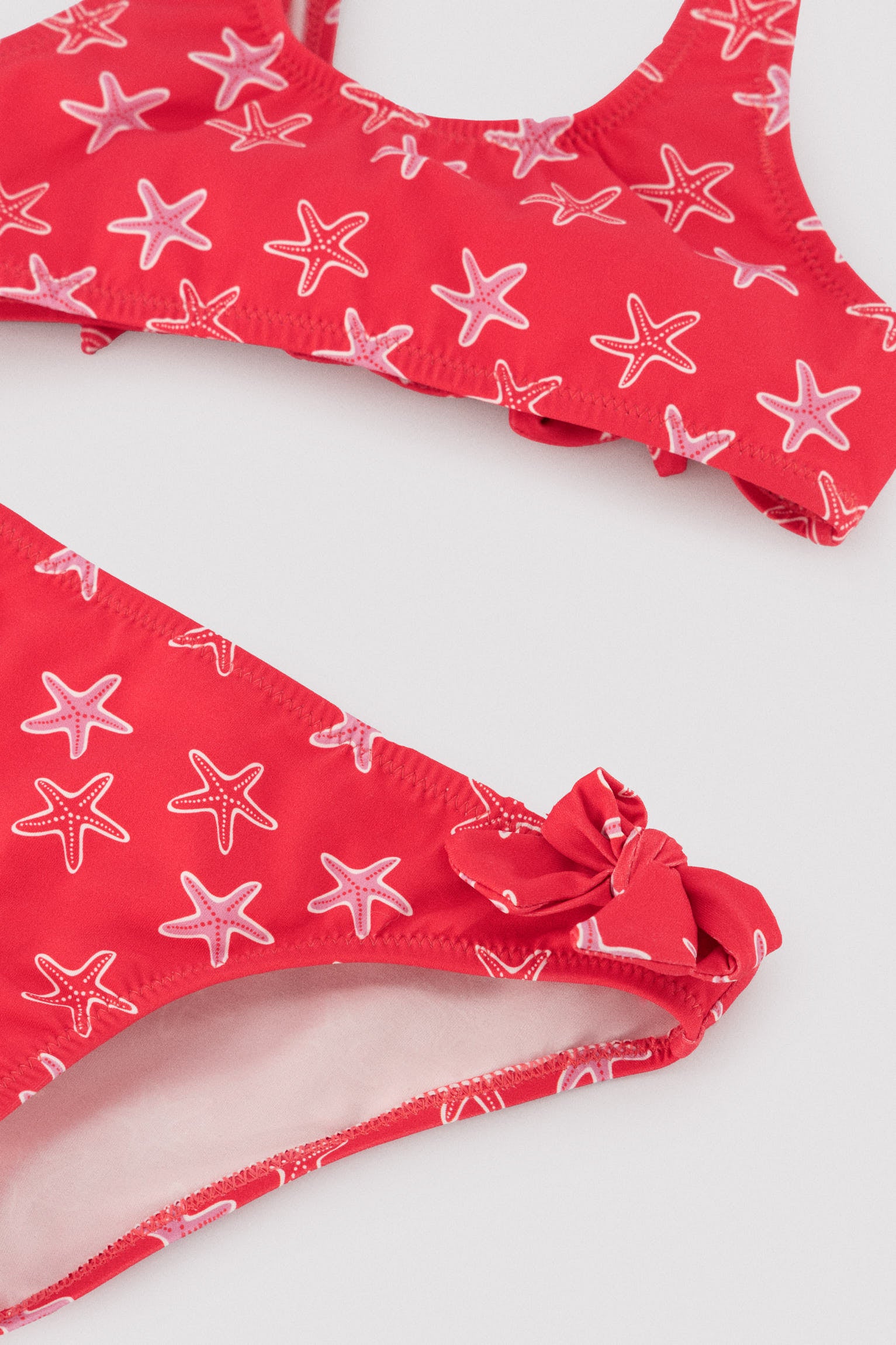 Girls' bikini with ruffle details and bows, starfish print