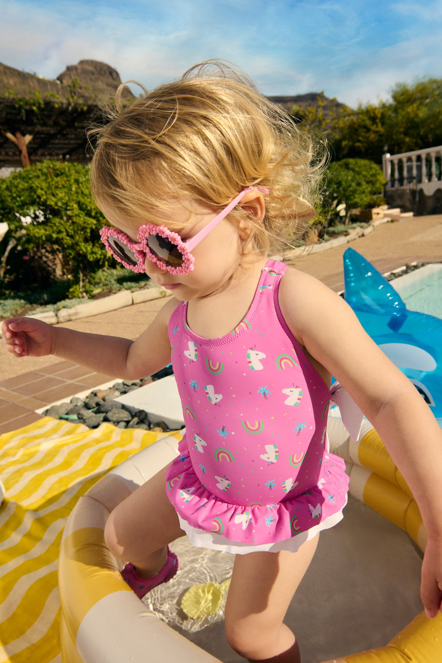 Baby girl swimsuit with ruffle and bow details, unicorn print
