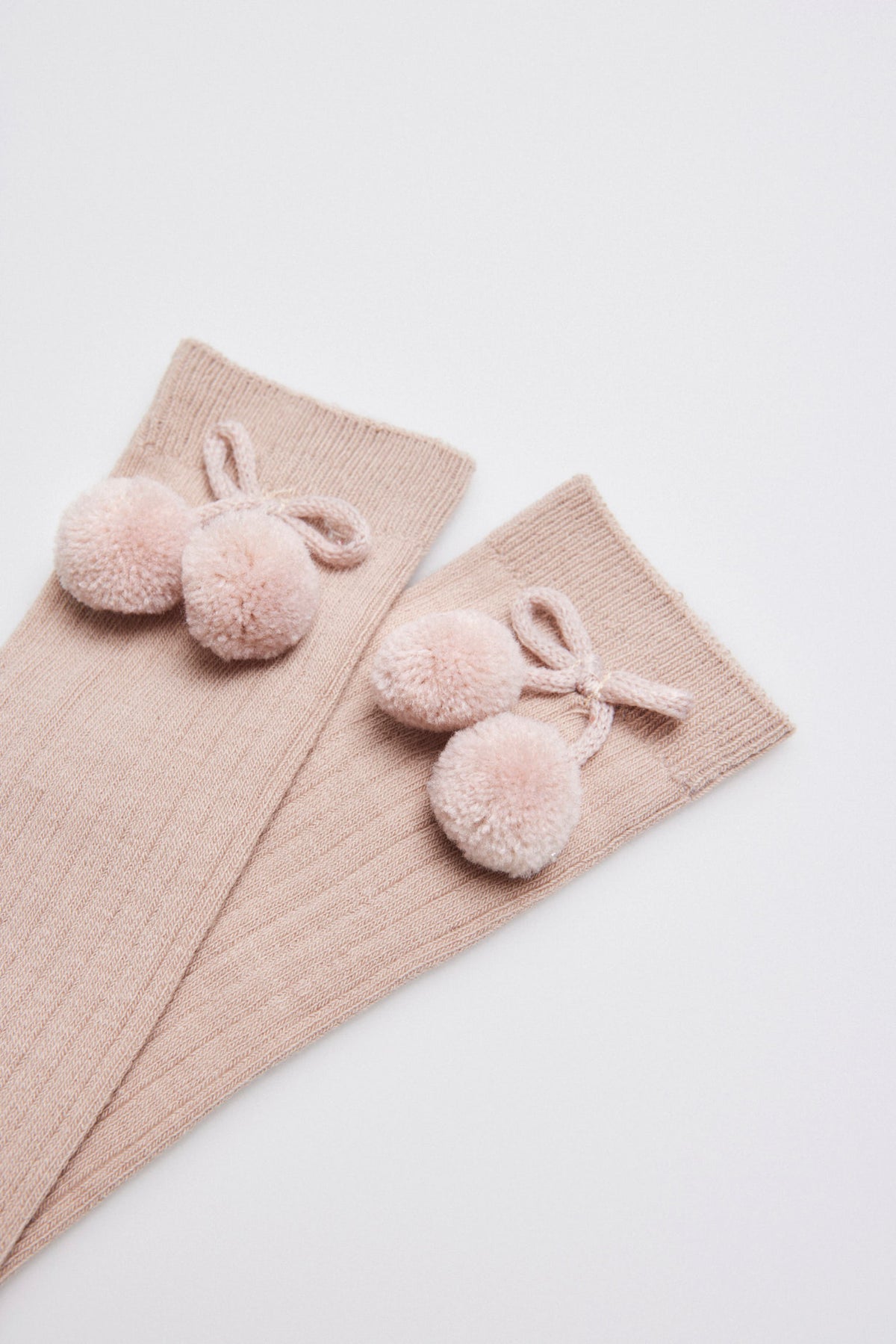 Children's long beige socks with pompom details