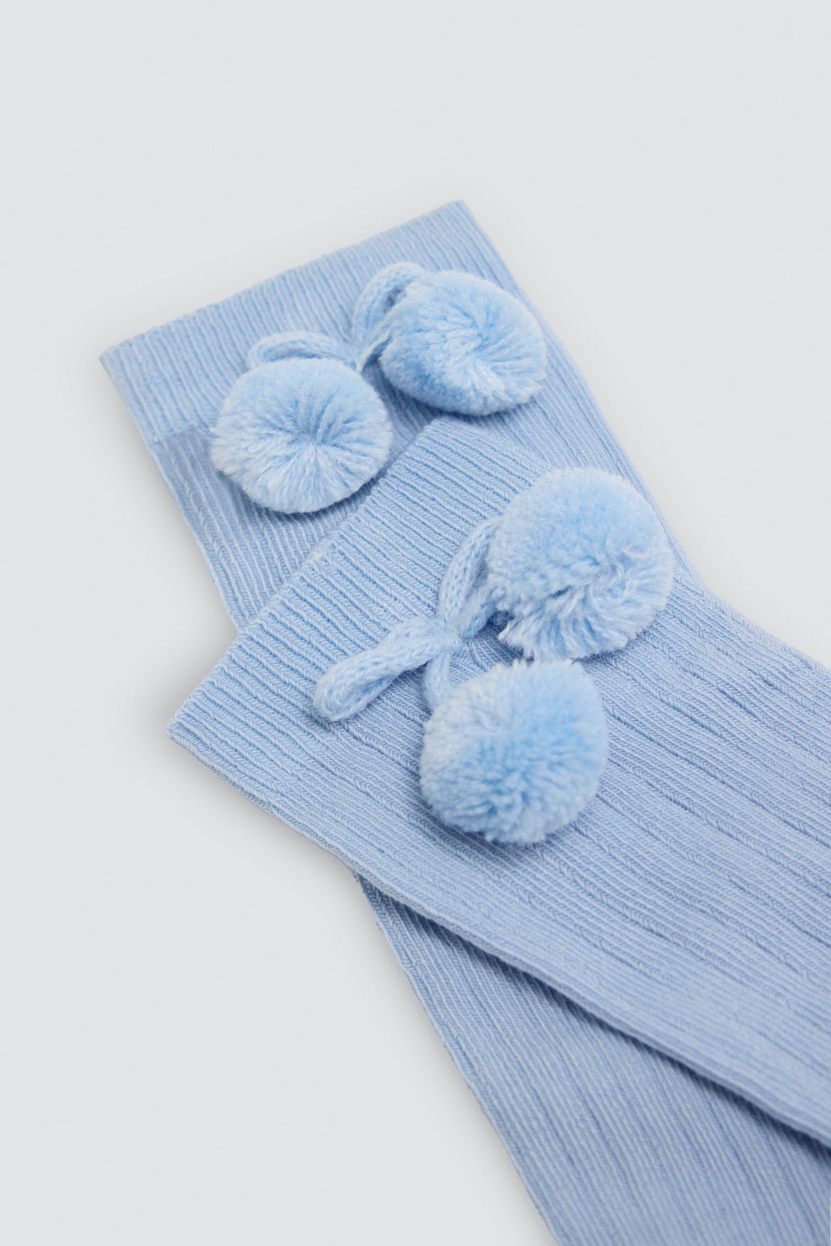 Children's long blue socks with pompom details