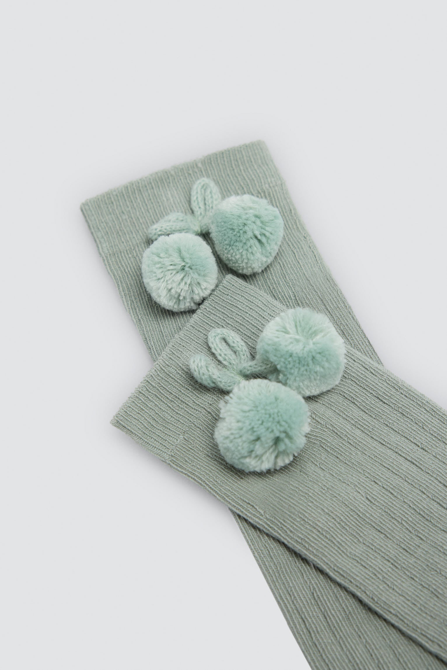 Children's long green socks with pompom details