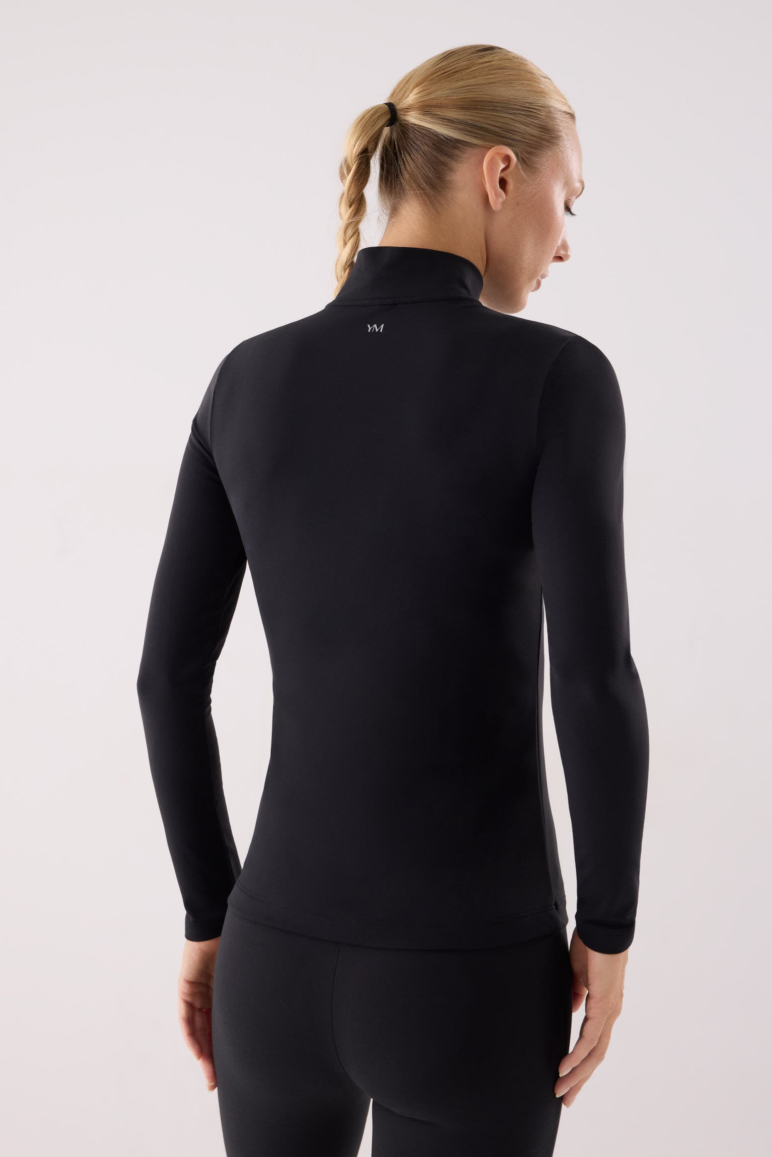 camiseta deportiva manga larga con media cremallera gimnasio en negro vista en movimiento para entrenamientos tejido transpirable con interior afelpado