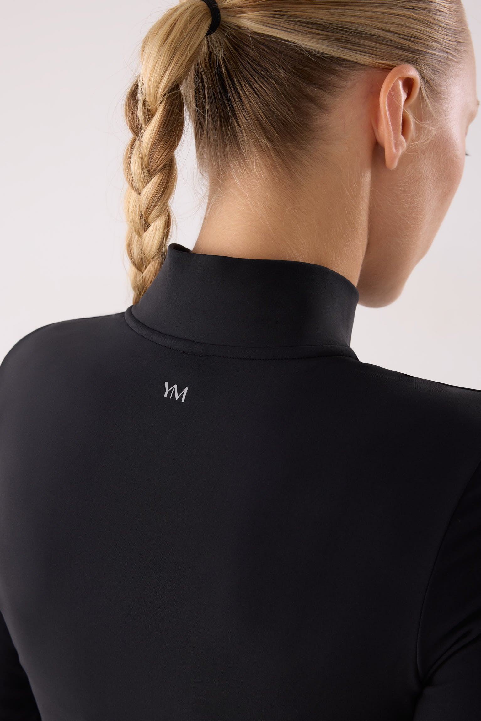camiseta deportiva manga larga con media cremallera gimnasio en negro detalle ajuste silueta tejido transpirable con interior afelpado
