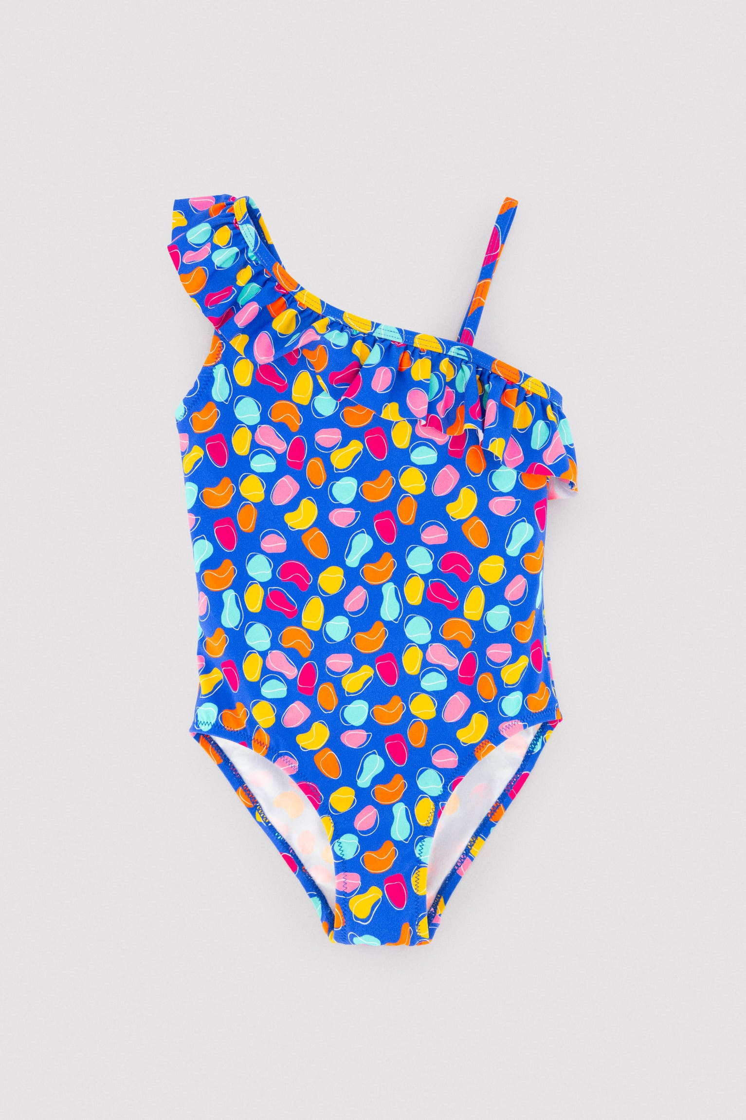 Asymmetrical swimsuit for girls with ruffle detail and organic-shaped print cut-out