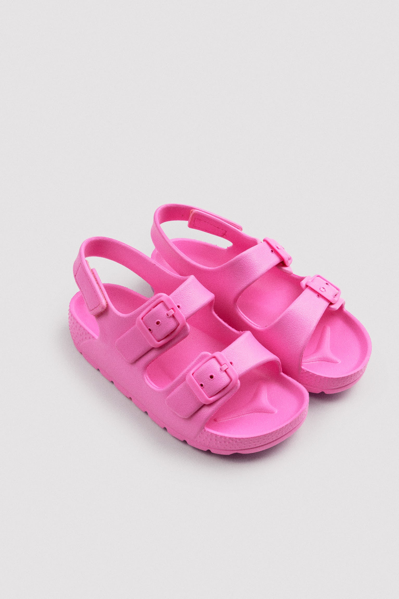 Pink children's flip-flops with adjustable buckles and velcro
