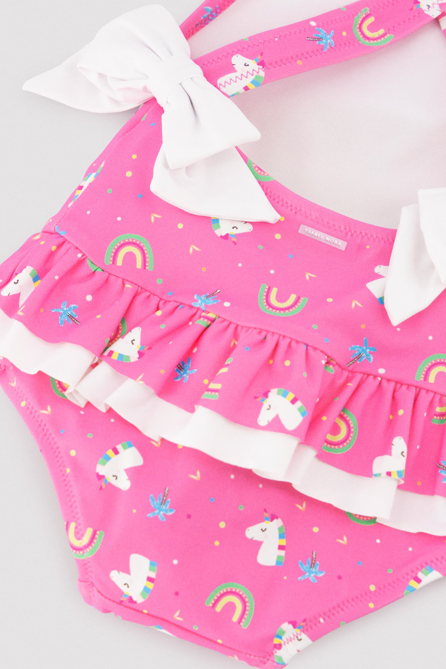 Baby girl swimsuit with ruffle and bow details, unicorn print