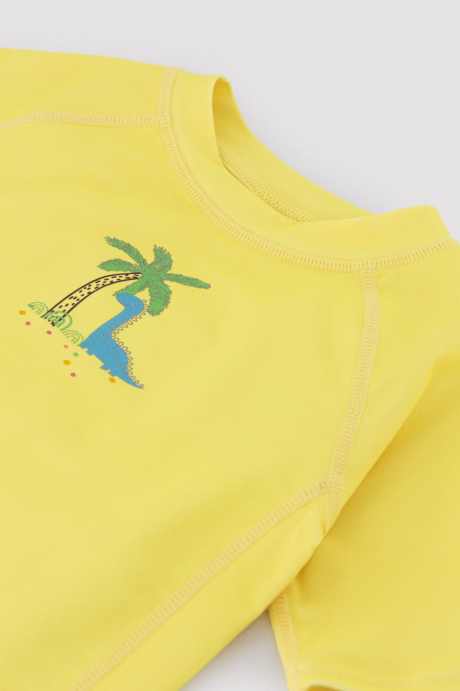 Baby swim shirt with dinosaur and palm tree print